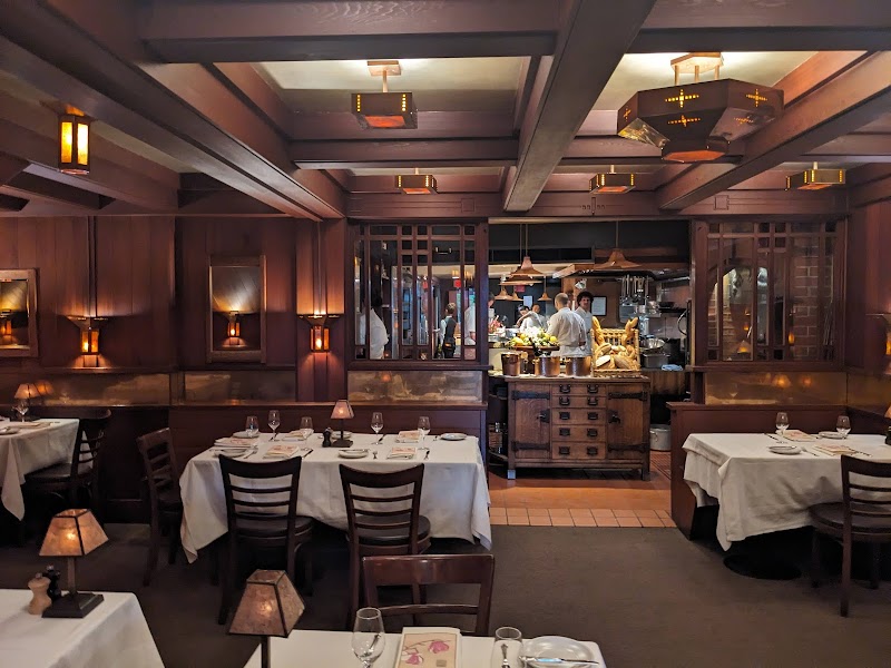 Chez Panisse dining room, warmly lit with seasonal arrangements